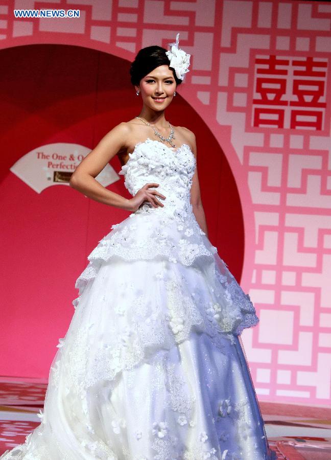 A model presents a creation at a wedding dress show during the 70th Valentine's Wedding Service and Banquet Expo in south China's Hong Kong, Feb. 16, 2013. The three-day Expo kicked off on Friday at Hong Kong Convention and Exhibition Center. (Xinhua/Jin Yi) 