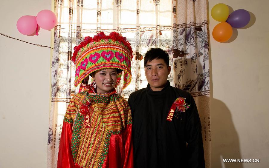 Ji Junxiang (R) and Zhang Lu, a wedding couple of the Lisu ethnic group, pose for photos in their marital residence in Xinyu Village of Dechang County, southwest China's Sichuan Province, Feb. 15, 2013. Dechang's Lisu people live in family- or clan-based villages most of which locates on river valley slopes of around 1,500 to 3,000 meters above the sea level. They still practice a wedding tradition that has uncommon conventions including bridal face-shaving, outdoor wedding banquet and overnight group dance. (Xinhua/Jiang Hongjing) 