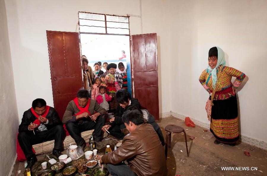 Hosts and witnesses of a traditional Lisu wedding have meal at the bride's home in Xinyu Village of Dechang County, southwest China's Sichuan Province, Feb. 15, 2013. Dechang's Lisu people live in family- or clan-based villages most of which locates on river valley slopes of around 1,500 to 3,000 meters above the sea level. They still practice a wedding tradition that has uncommon conventions including bridal face-shaving, outdoor wedding banquet and overnight group dance. (Xinhua/Jiang Hongjing) 