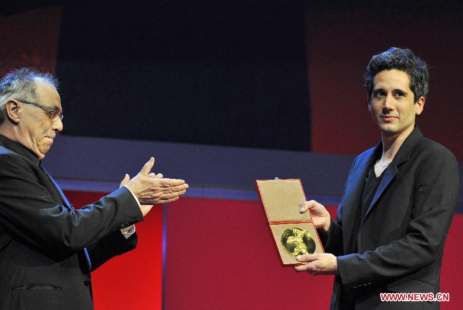 Director Jean-Bernand Marlin (R) receives the Golden Bear award for best film of the International Short film jury for "La Fugue" (The Runaway) during the awards ceremony at the 63rd Berlinale International Film Festival in Berlin, Feb. 16, 2013. (Xinhua/Ma Ning)