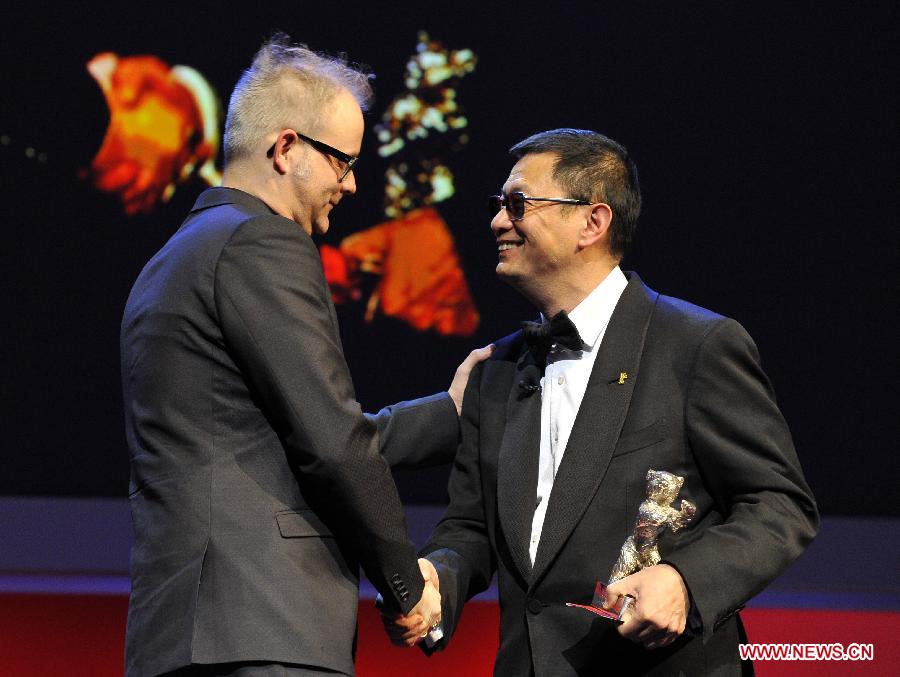 Director Wong Kar Wai (R) presents the Silver Bear for Alfred Bauer Prize (honouring innovation) to director Denis Cote for his film "Vic + Flo Saw a Bear" during the awards ceremony at the 63rd Berlinale International Film Festival in Berlin, Feb. 16, 2013. (Xinhua/Ma Ning) 