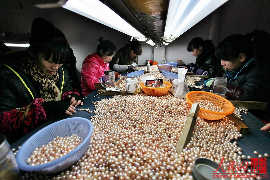Workers sort pearls in the factory.(People’s Daily Online/ Wang Chu) 