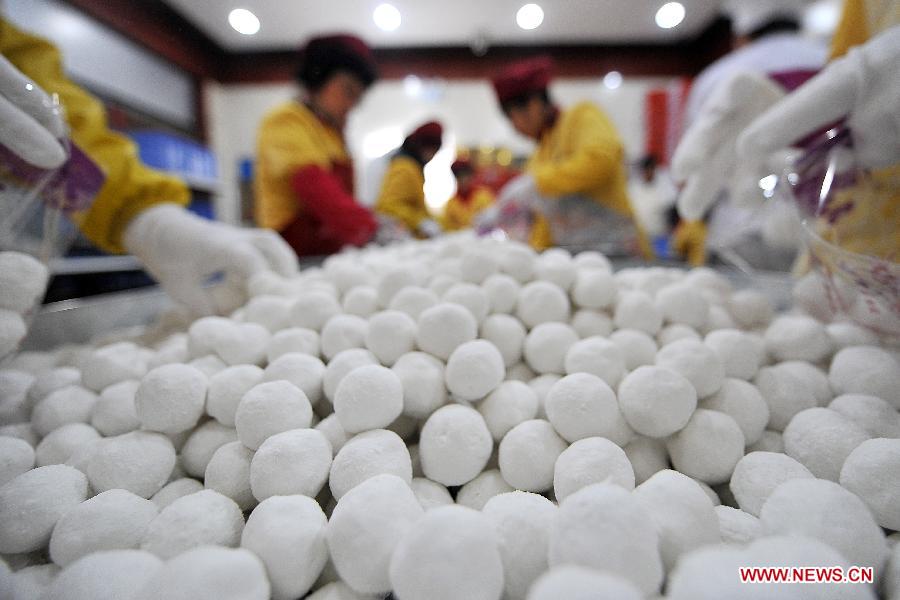 Staff members pack Yuanxiao, glutinous rice flour dumpling with sweetened stuffing, at a food shop in Taiyuan, capital of north China's Shanxi Province, Feb. 16, 2013. Yuanxiao is a traditional festive food for the Lantern Festival, which falls on Feb. 24 this year. (Xinhua/Zhan Yan)  