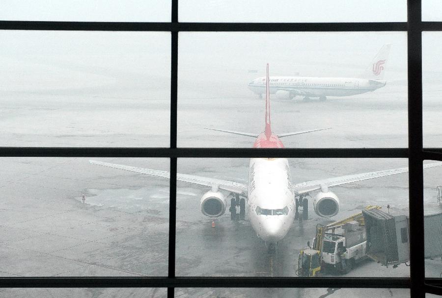 Airplanes wait in fog at the Beijing Capital International Airport in Beijing, capital of China, Feb. 17, 2013. (Xinhua/Ma Ruzhuang)