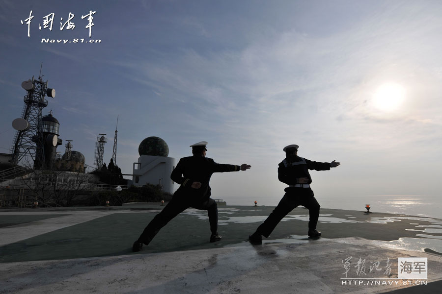 Two soldiers make the "aircraft carrier style" on the helipad of the islet. (Navy.81.cn/ Jiang Shan)