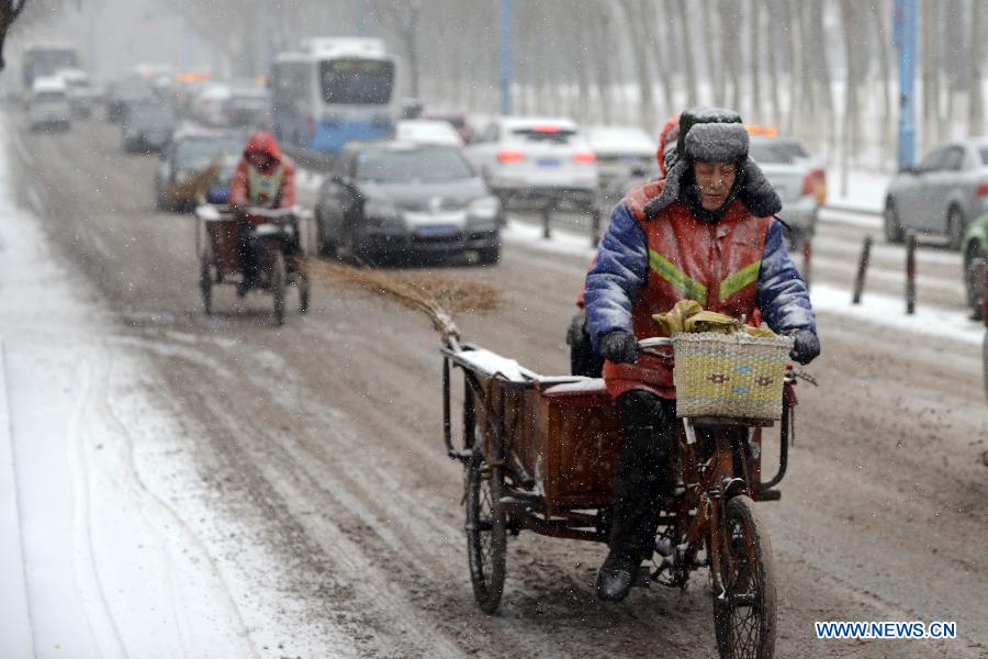 Sanitation workers ride in snow in Changchun, capital of northeast China's Jilin Province, Feb. 17, 2013. Snow hit the province on Sunday. (Xinhua/Lin Hong) 