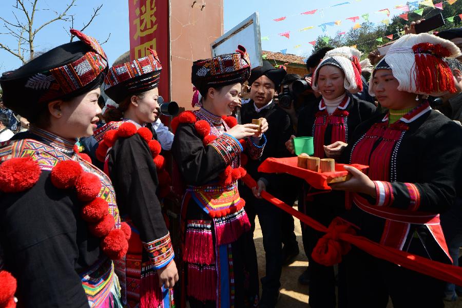 Villagers of the Yao ethnic group drink a toast to the guests to participate in the activity of casting earthbags in Wei'e Yao Ethnic Group Village in Leli Township of Tianlin County, south China's Guangxi Zhuang Autonomous Region, Feb. 17, 2013. People here follow a tradition to cast earthbags to celebrate the Chinese New Year. (Xinhua/Wei Wanzhong) 