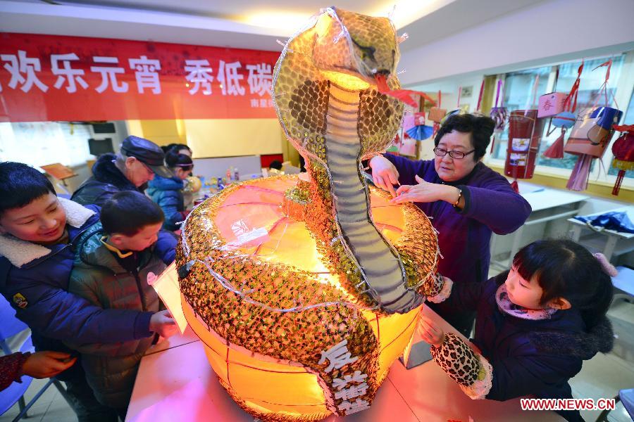 Citizens make a lantern from used matierals in a community in Hangzhou, capital of east China's Zhejiang Province, Feb. 18, 2013. Chinese traditional Lantern Festival this year falls on Feb. 24, 2013. (Xinhua/Li Zhong) 