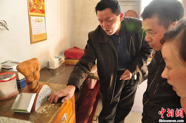 An undated photo shows Luo demonstrates the incredible process to two onlookers. (Photo/ Chinanews.com)