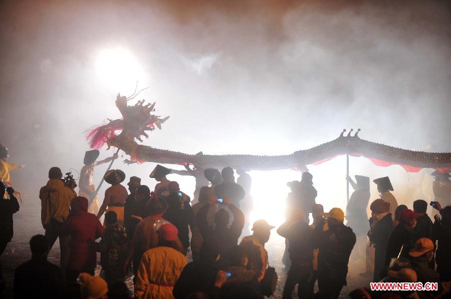 People perform dragon dance in firecrackers in Binyang County of south China's Guangxi Zhuang Autonomous Region, Feb. 20, 2013. The Binyang-style dragon dance is a derivative of traditional dragon dance in which performers hold dragon on poles and walk through floods of firecrackers. The dance, dating back to over 1,000 years ago, was listed as a state intangible cultural heritage in 2008. (Xinhua/Huang Xiaobang) 
