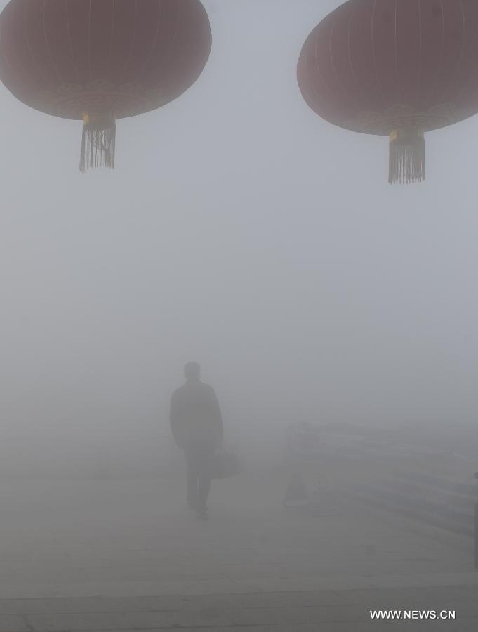A citizen walks amid heavy fog in Pingxian County, north China's Hebei Province, Feb. 22, 2013. Some parts of Hebei Province were hit by fog and smog on Feb. 22 morning and the provincial meteorological bureau has issued a red alert. (Xinhua/Wang Xiao) 