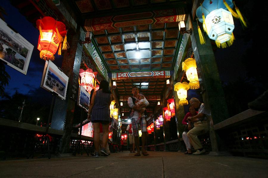 People walk past Chinese lanterns during the 12th China-Philippines Traditional Cultural Festival and Suzhou Cultural Exhibition at the Rizal Park in Manila, the Philippines, Feb. 23, 2013. The 12th China-Philippines Traditional Cultural Festival and Suzhou Cultural Exhibition opened here on Saturday, one day ahead of the Chinese Lantern Festival. (Xinhua/Rouelle Umali)