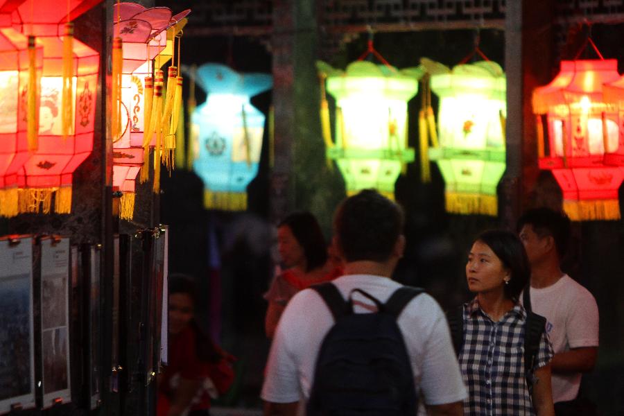 People walk past Chinese lanterns during the 12th China-Philippines Traditional Cultural Festival and Suzhou Cultural Exhibition at the Rizal Park in Manila, the Philippines, Feb. 23, 2013. The 12th China-Philippines Traditional Cultural Festival and Suzhou Cultural Exhibition opened here on Saturday, one day ahead of the Chinese Lantern Festival. (Xinhua/Rouelle Umali)
