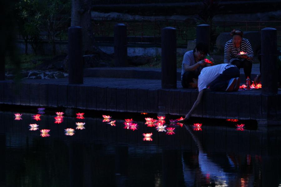 People light floating Chinese lotus lights during the 12th China-Philippines Traditional Cultural Festival and Suzhou Cultural Exhibition at the Rizal Park in Manila, the Philippines, Feb. 23, 2013. The 12th China-Philippines Traditional Cultural Festival and Suzhou Cultural Exhibition opened here on Saturday, one day ahead of the Chinese Lantern Festival. (Xinhua/Rouelle Umali)