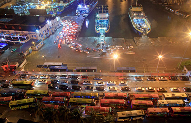 Vehicles that were trapped by a heavy fog leave a port in Haikou, Hainan province, at late night of Feb. 15, 2013. 46,000 passengers and 8,700 vehicles have left the Port of Haikou from 8 p.m. Friday to 8 a.m. Saturday, after being trapped by a heavy fog that disrupted the waterway traffic across the Qiongzhou Strait. (Photo/Xinhua)