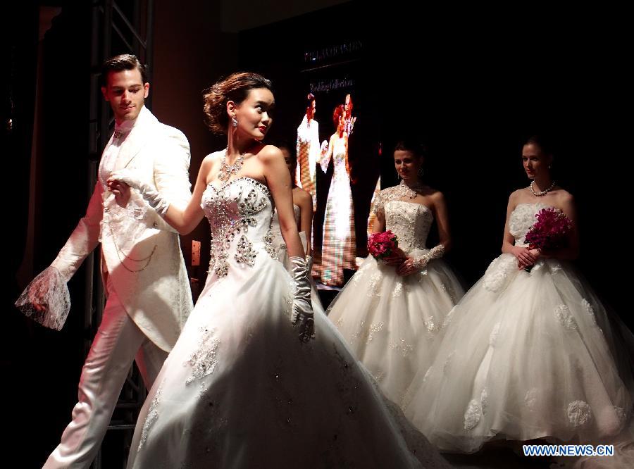 Models present creations at an international wedding dress show featuring 70 new designs in Shanghai, east China, Feb. 23, 2013. (Xinhua/Ren Long)