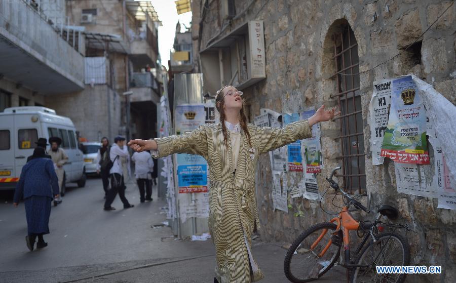 An Ultra-Othordox Jewish man walks in a street during Purim festival, a Jewish colorful and popular holiday, in Jerusalem, on Feb. 25, 2013. In Jerusalem, Purim was celebrated from sunset on Sunday, Feb. 24, until sunset on Monday, Feb. 25, one day later than it is in the rest of the world. (Xinhua/Yin Dongxun) 