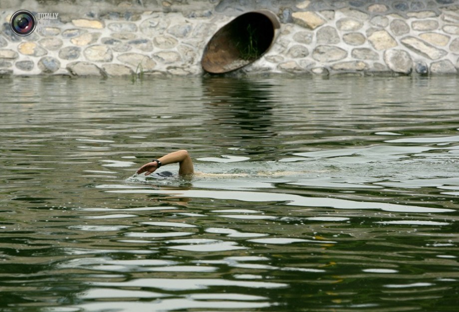 A man swims in a polluted river in Beijing. (File Photo)