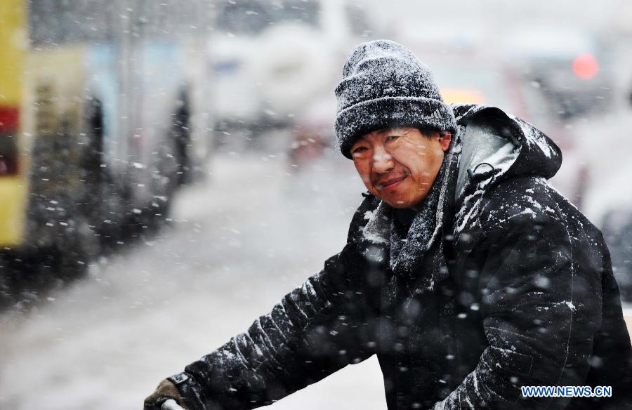 A man pushes a bike in the snow in Harbin, capital of northeast China's Heilongjiang Province, Feb. 28, 2013. Most areas of Heilongjiang witnessed snowfall on Thursday. (Xinhua/Wang Jianwei) 