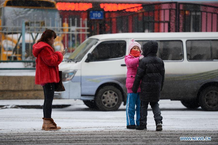 People wait for taxi in the snow in Harbin, capital of northeast China's Heilongjiang Province, Feb. 28, 2013. Most areas of Heilongjiang witnessed snowfall on Thursday. (Xinhua/Wang Kai) 