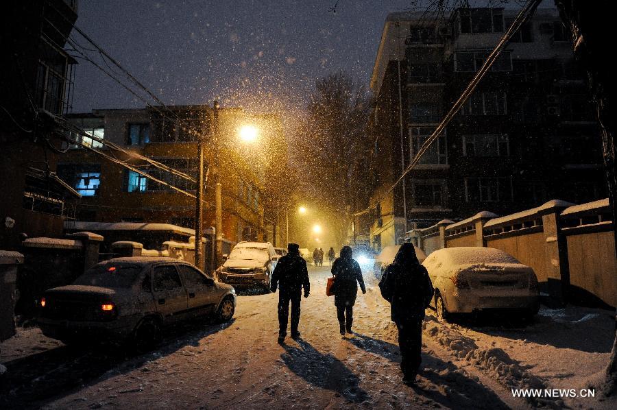 People walk at a snowy night in Changchun, capitalf of northeast China's Jilin Province, Feb. 28, 2013. Temperature in north China is forecasted to drop six to 12 degrees celcius due to a coming cold front while heavy snowfall may likely to hit the northeast provinces, accoding to China's National Meteorological Centre on Thursday. (Xinhua/Xu Chang)