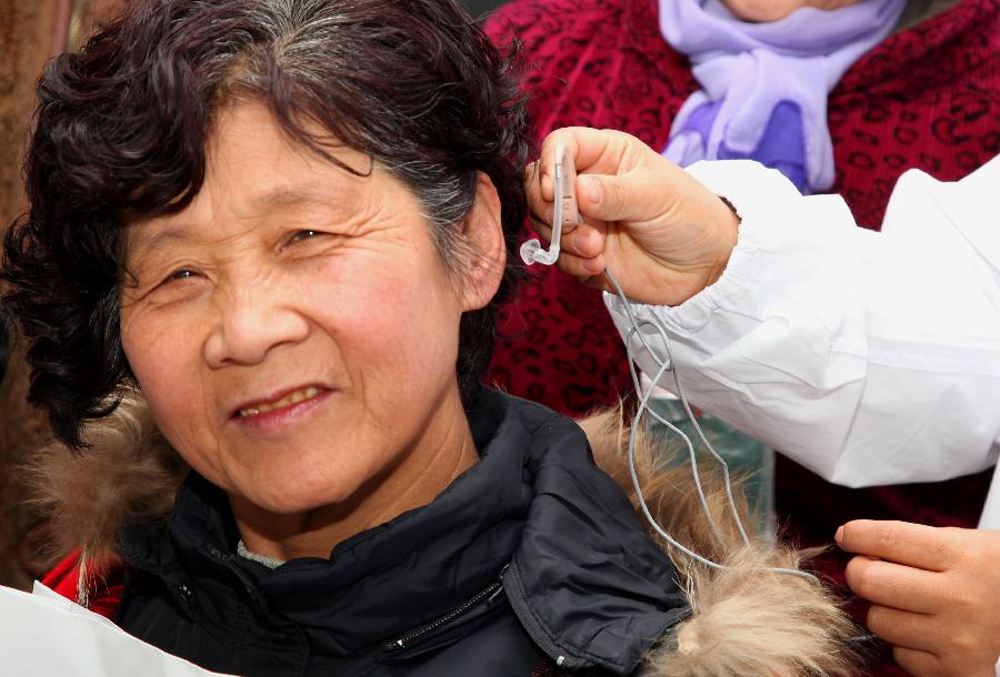 A woman named Chang Jinglan experiences the hearing-aid during an activity celebrating the upcoming Ear-care Day, which falls on March 3 every year, in Beijing, capital of China, March 1, 2013. (Xinhua/Bu Xiangdong)