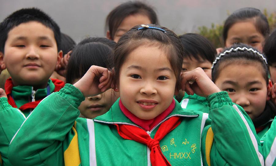 Students do ear exercises during an activity celebrating the upcoming Ear-care Day, which falls on March 3 every year, at a primary school in Zaozhuang City, east China's Shandong Province, Feb. 28, 2013. (Xinhua/Sun Zhongzhe)