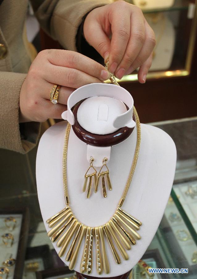 A Palestinian woman picks a necklace made by Russian gold at a gold market in the West Bank city of Nablus on March 2, 2013. (Xinhua/Ayman Nobani) 