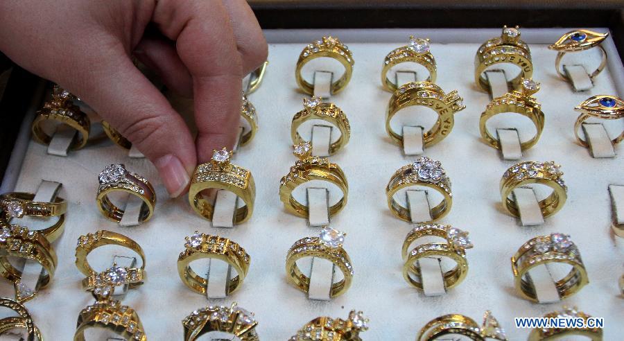 A Palestinian woman picks rings made by Russian gold at a gold market in the West Bank city of Nablus on March 2, 2013. (Xinhua/Ayman Nobani) 
