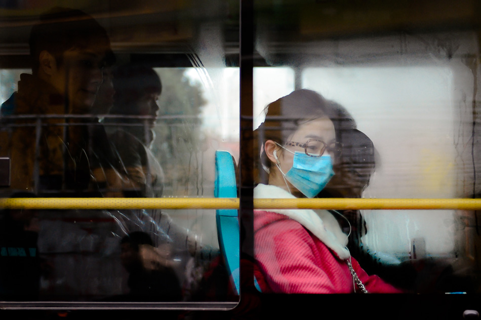 Fearing the pollution brought by fog and haze weather, a passenger still wears mask in a bus in Jinan of Shandong on Feb. 26, 2013. (Xinhua/Guo Xulei)