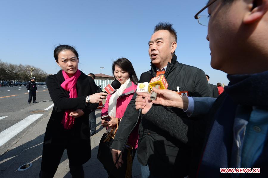 Chen Kaige (2nd R), a member of the 12th National Committee of the Chinese People's Political Consultative Conference (CPPCC), receives an interview outside the Great Hall of the People in Beijing, capital of China, March 3, 2013. The first session of the 12th CPPCC National Committee opened in Beijing on March 3. (Xinhua/Qin Qing)