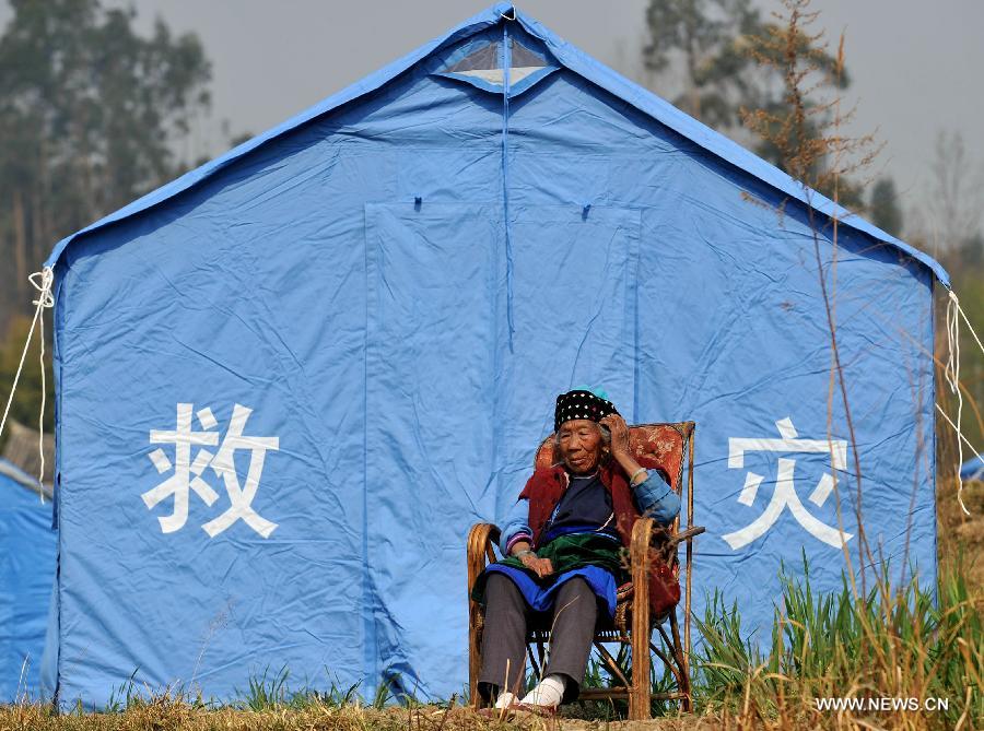 A man sits in front of a relief tent at Qiandian Village of Liantie Township in Eryuan County of Dali Bai Autonomous Prefecture, southwest China's Yunnan Province, March 4, 2013. A 5.5-magnitude earthquake hit Eryuan County on March 3. Thirty people have been confirmed injured, while some 21,000 people have been evacuated. (Xinhua/Lin Yiguang) 