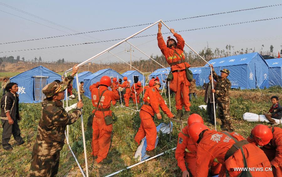 Workers pitch relief tents at Qiandian Village of Liantie Township in Eryuan County of Dali Bai Autonomous Prefecture, southwest China's Yunnan Province, March 4, 2013. A 5.5-magnitude earthquake hit Eryuan County on March 3. Thirty people have been confirmed injured, while some 21,000 people have been evacuated. (Xinhua/Lin Yiguang) 