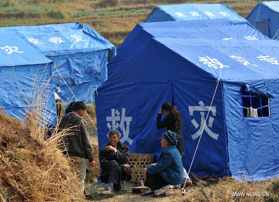 People chat in front of a relief tent at Qiandian Village of Liantie Township in Eryuan County of Dali Bai Autonomous Prefecture, southwest China's Yunnan Province, March 4, 2013. A 5.5-magnitude earthquake hit Eryuan County on March 3. Thirty people have been confirmed injured, while some 21,000 people have been evacuated. (Xinhua/Lin Yiguang) 