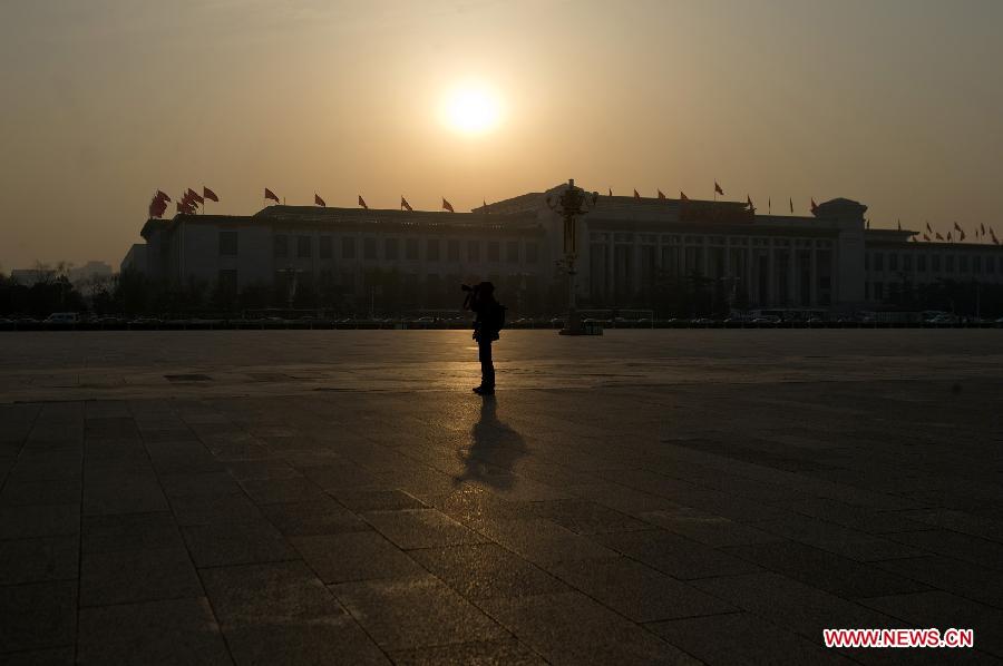 A journalist takes photos at the Tian'anmen Square in Beijing, capital of China, March 5, 2013. The first session of the 12th National People's Congress (NPC) will open at the Great Hall of the People in Beijing on March 5. (Xinhua/Guo Chen)
