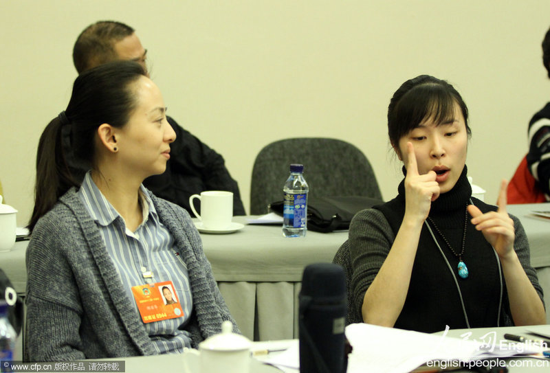 Dancer Tai Lihua (L) and a translator cooperate very well at a discussion panel of literature and arts circle of 12th CPPCC National Committee on March 04, 2013. (Photo/ People's Daily Online)