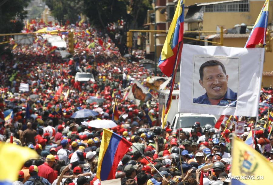 Residents participate in the funeral procession in honor of Venezuelan President Hugo Chavez on the streets of Caracas, capital of Venezuela, on March 6, 2013. On Tuesday afternoon, Venezuelan President, Hugo Chavez, died after fighting for almost two years with a cancer disease. The body of Chavez is moved from the health center to the Military Academy in southern Caracas, inside Tiuna's Fort. (Xinhua/Juan Carlos Hernandez)