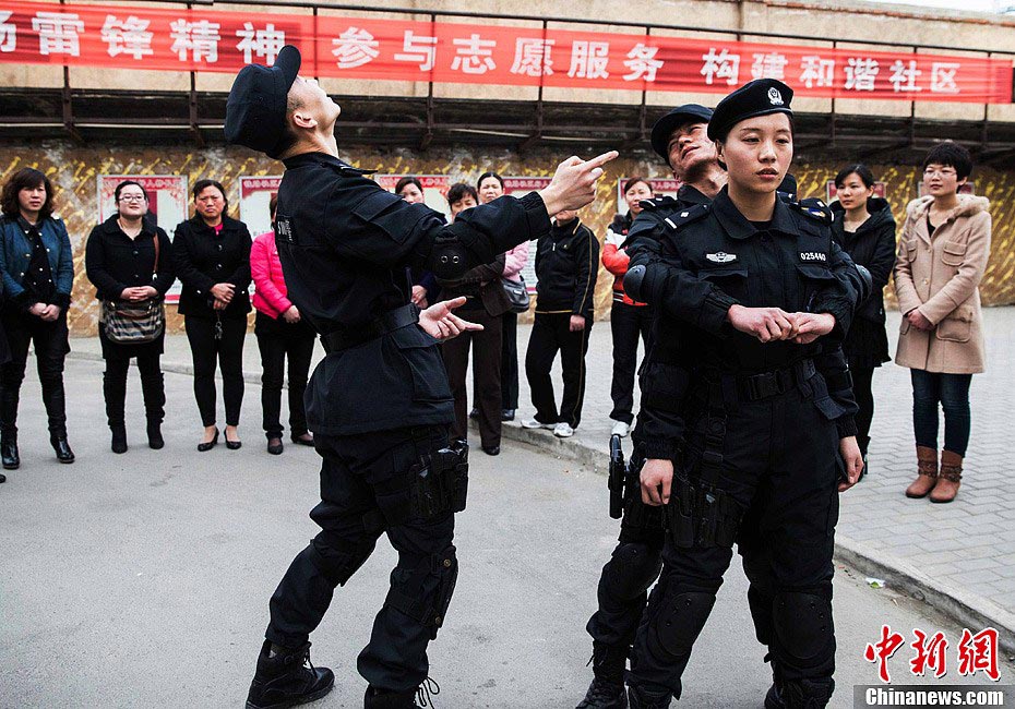 Members of Special Police unit of Huaibei Public Security Bureau in eastern China’s Anhui province demonstrate self-defense skills for local female workers with the hope of improving their awareness and ability of self-protection, March 6, 2013. (Chinanews.com/Han Suyuan) 