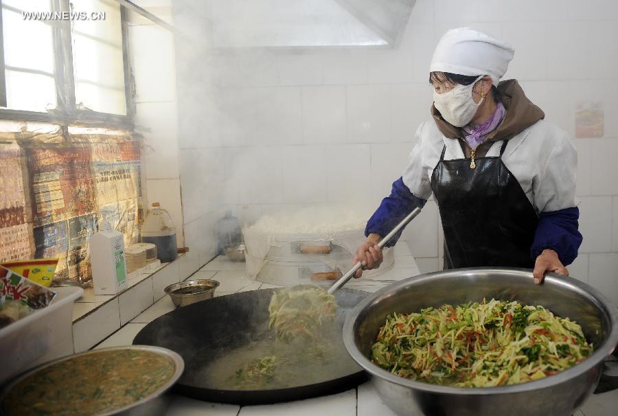 A cook prepares lunch for pupils at Dabao Primary School in Hongyao Township of Xiji County, northwest China's Ningxia Hui Autonomous Region, March 6, 2013. (Xinhua/Li Ran)