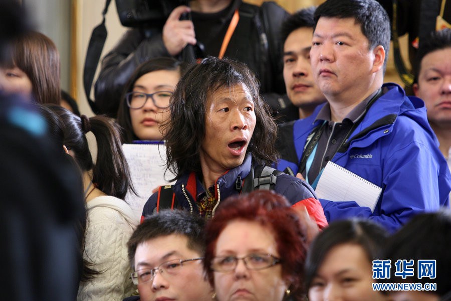 A press conference for the first session of the 12th NPC is held in the Great Hall of the People on March 4, 2013 in Beijing. A reporter attracts people's attention by his eye-caching looking. (Photo/Xinhua)