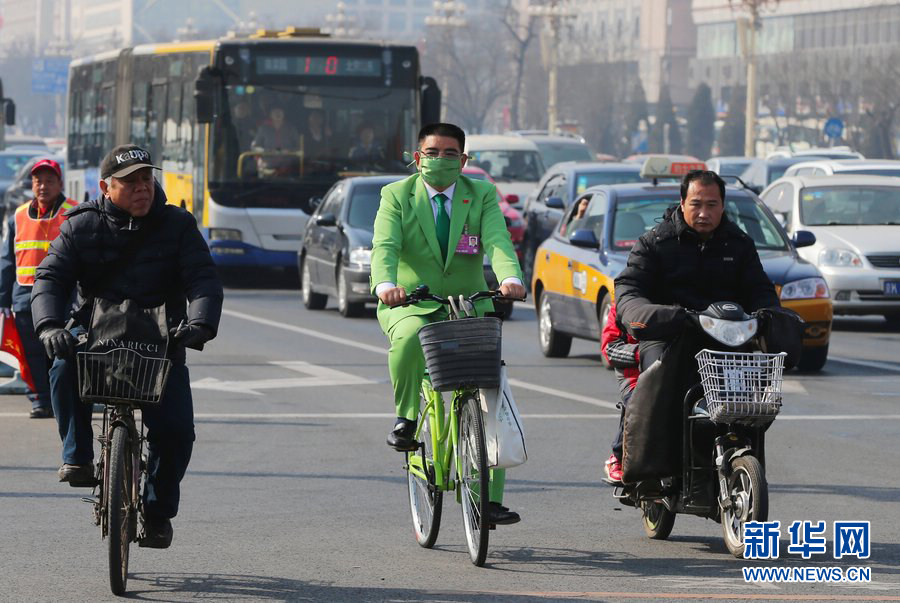 Chen Guangbiao, the millionaire philanthropist, rides a bicycle to attend the first session of the 12th CPPCC National Committee as a nonvoting member on March 3, 2013. To promote environment protection, he was dressed in green. (Photo/Xinhua)