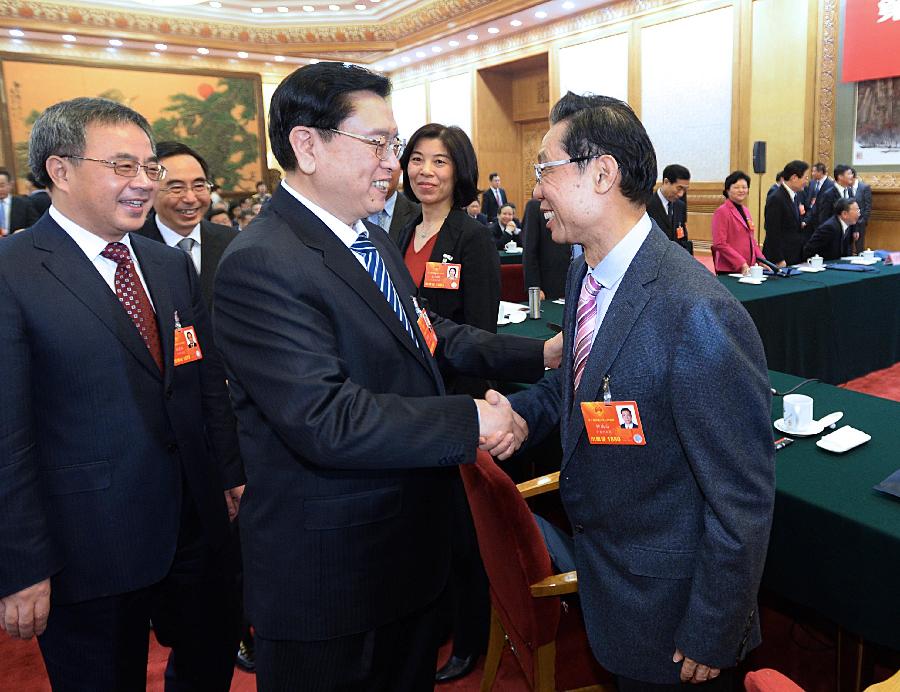Zhang Dejiang (C, front), a member of the Standing Committee of the Political Bureau of the Communist Party of China (CPC) Central Committee, shakes hands with Zhong Nanshan, a deputy to the 12th National People's Congress (NPC), while joining a discussion with deputies attending the first session of the 12th NPC from south China's Guangdong Province, in Beijing, capital of China, March 8, 2013. (Xinhua/Li Tao)