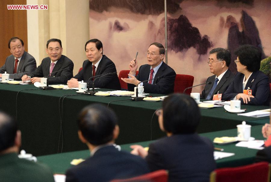 Wang Qishan (4th L), a member of the Standing Committee of the Political Bureau of the Communist Party of China (CPC) Central Committee, joins a discussion with deputies from east China's Anhui Province, who attend the first session of the 12th National People's Congress (NPC), in Beijing, capital of China, March 8, 2013. (Xinhua/Ma Zhancheng)