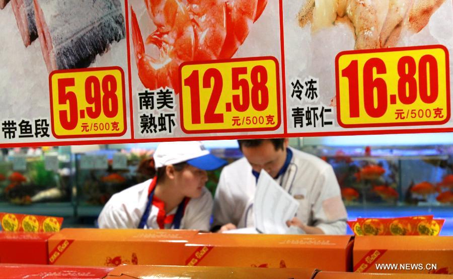 Staff members check goods behind price tags at a supermarket in Shanghai, east China, March 9, 2013. China's consumer price index (CPI), a main gauge of inflation, grew 3.2 percent year on year in February, the highest level in ten months, the National Bureau of Statistics announced Saturday. (Xinhua/Pei Xin)