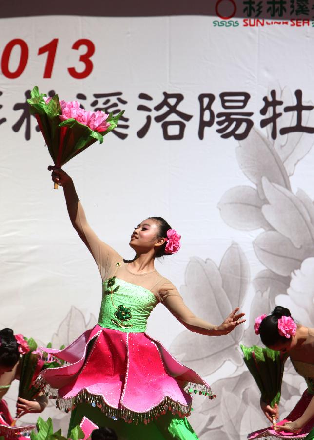 Dancers perform on the opening of a peony cultural festival in Nantou of southeast China's Taiwan, March 9, 2013. A peony cultural festival was opened at the Sun Link Sea forest park on March 9. Over 8,000 peonies of some 50 species from central China's Henan Province will be exhibited on an attached show till the end of May. (Xinhua/Xie Xiudong) 