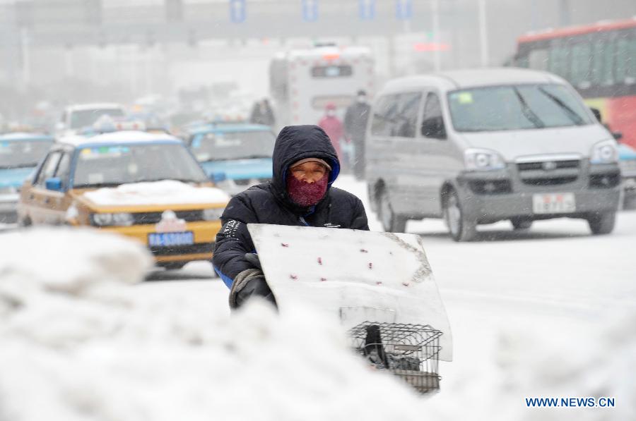 A man rides on a snow-covered street in Harbin, capital of northeast China's Heilongjiang Province, March 9, 2013. Local meteorological bureau issued a blue alert against heavy snowfall on Saturday morning. (Xinhua/Wang Song)