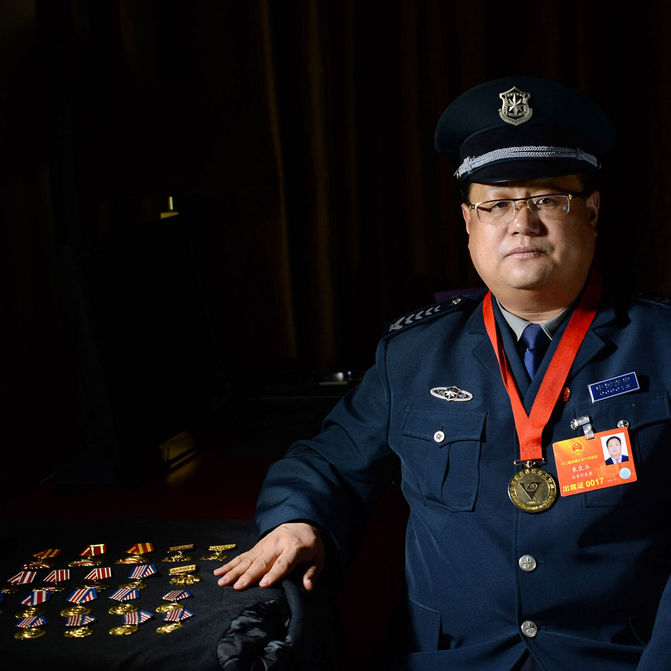 Zhu Liangyu, a NPC deputy, takes photos with his awards in Beijing, March 6, 2013. Zhu said his dream is migrant workers will eventually enjoy fair treatment with access to house, health care and comfortable life in their old age. (Xinhua/Jin Liangkuai) 