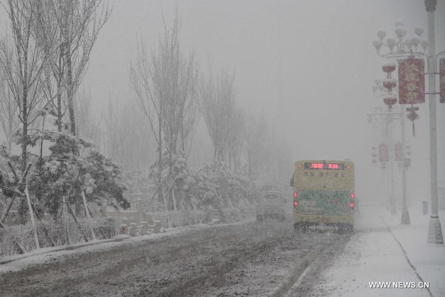 Vehicles move in snow in Pingquan County in north China's Hebei Province, March 12, 2013. Affected by a cold front, the northern part of Hebei received snowfall on Tuesday. (Xinhua/Wang Xiao)