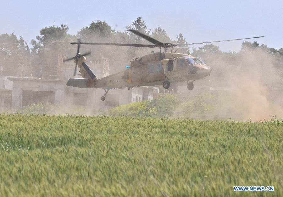 An Israeli Air Force helicopter for accident investigation lands at the site where an Israeli military helicopter crashed earlier at Kibbutz Revadim in southern Israel on March 12, 2013. An Israel Air Force Bell AH-1 Cobra helicopter crashed into a wheat field at Kibbutz Revadim, killing two crew members, during a training flight on early Tuesday morning, confirmed by Israeli army spokesperson. (Xinhua/Yin Dongxun) 