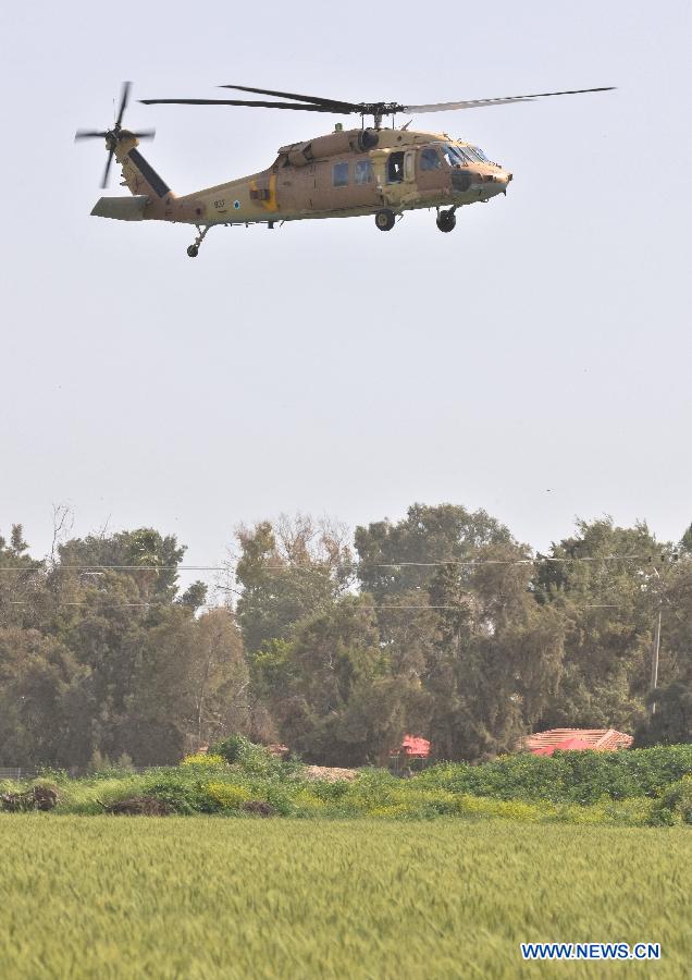 An Israeli Air Force helicopter for accident investigation lands at the site where an Israeli military helicopter crashed earlier at Kibbutz Revadim in southern Israel on March 12, 2013. An Israel Air Force Bell AH-1 Cobra helicopter crashed into a wheat field at Kibbutz Revadim, killing two crew members, during a training flight on early Tuesday morning, confirmed by Israeli army spokesperson. (Xinhua/Yin Dongxun)